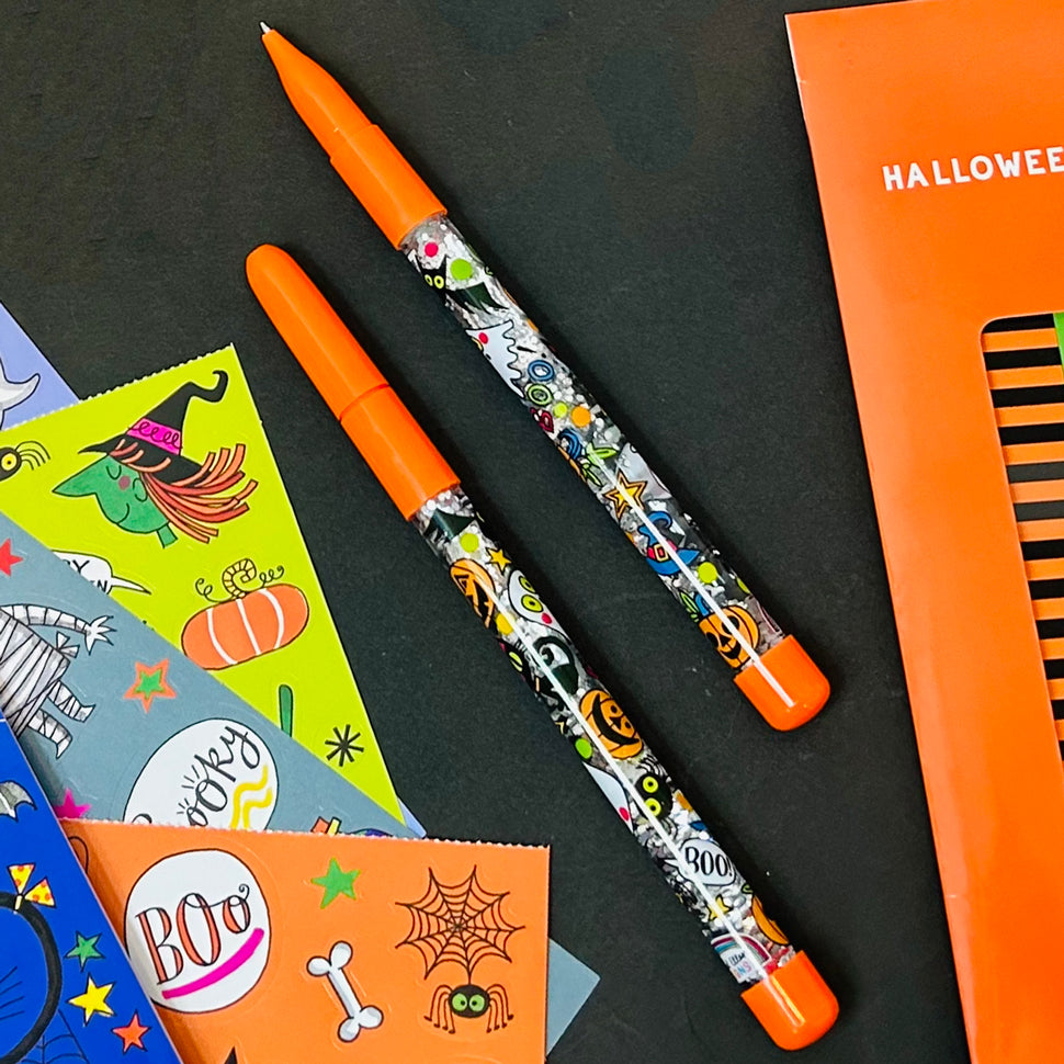 Halloween-themed pen with orange cap on a black background